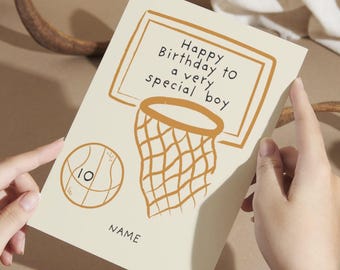 May include: A birthday card with a basketball theme. The card features a basketball hoop and a basketball with the number 10. The text reads "Happy Birthday to a very special boy" and "NAME". The card is cream-colored with orange illustrations.