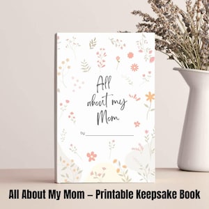 Könnte beinhalten: Ein druckbares Erinnerungsbuch mit floralem Design. Der Umschlag zeigt den Text "Alles über meine Mama" und einen Platz für den Namen des Kindes.