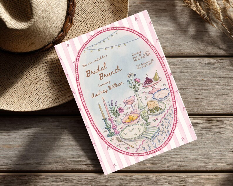 May include: A rectangular invitation card with a pink and white striped border featuring small bow icons. The center oval illustration depicts a table set for a Bridal Brunch honoring Audrey Wilson, with candles, flowers, fruit, and dinnerware.
