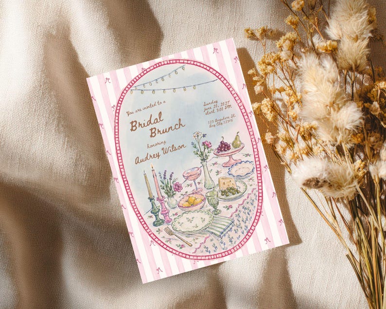 May include: A rectangular invitation card with a pink and white striped border featuring small bows. The center oval illustration depicts a table set for a Bridal Brunch for Audrey Wilson, including candles, flowers, fruit, and plates of food.