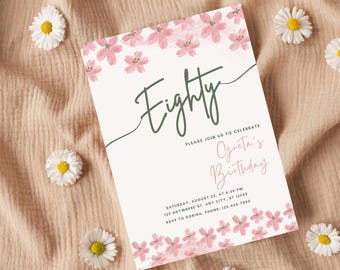 May include: An invitation with the word "Eighty" in green script, and the text "Please join us to celebrate Greta's Birthday." Pink floral accents frame the text. White daisies are scattered around the invitation on a peach-colored fabric.