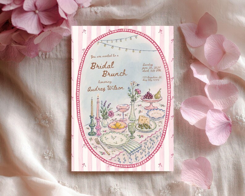 May include: A rectangular invitation card with a pink and white striped border featuring an oval illustration of a table set for a bridal brunch. The text reads: You are invited to a Bridal Brunch honoring Audrey Wilson, Sunday June 20, 2027, 3:00 PM, 123 Anywhere St, Any City 12345.