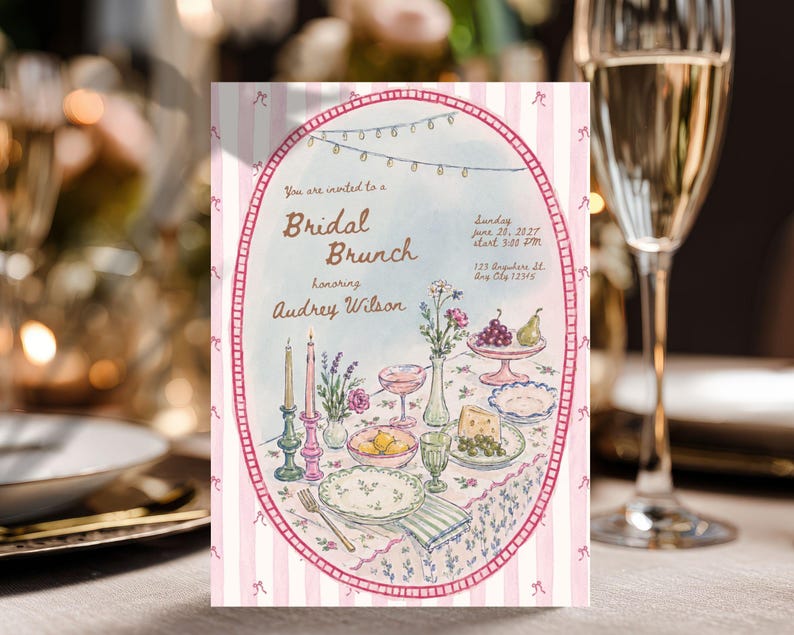 May include: A rectangular invitation card with a pink and white striped border featuring an oval frame. The text reads: You are invited to a Bridal Brunch honoring Audrey Wilson, Sunday June 20, 2027, 3:00 PM, 123 Anywhere St. Any City 12345.