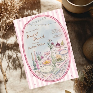 May include: A rectangular invitation card with a pink and white striped border featuring a central oval illustration of a table set for a bridal brunch. The text reads: You are invited to a Bridal Brunch Honoring Audrey Wilson Sunday June 20, 2027 start 3:00 PM 123 Anywhere St. Any City 12345.