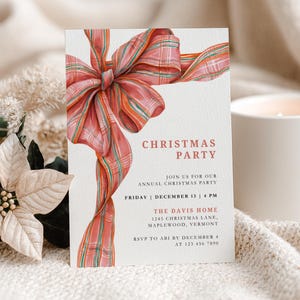 May include: A Christmas party invitation featuring a watercolour illustration of a red and orange plaid bow. The invitation includes the text "Christmas Party" and event details. A white candle and poinsettia are in the background.