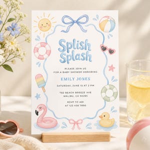 Peut inclure: Une invitation à une baby shower avec un design à l'aquarelle. L'invitation présente les mots "Splish Splash" en bleu, ainsi que des illustrations d'un soleil, d'un ballon de plage, de lunettes de soleil et d'un flotteur flamant rose. L'invitation est tenue par un support en bois.