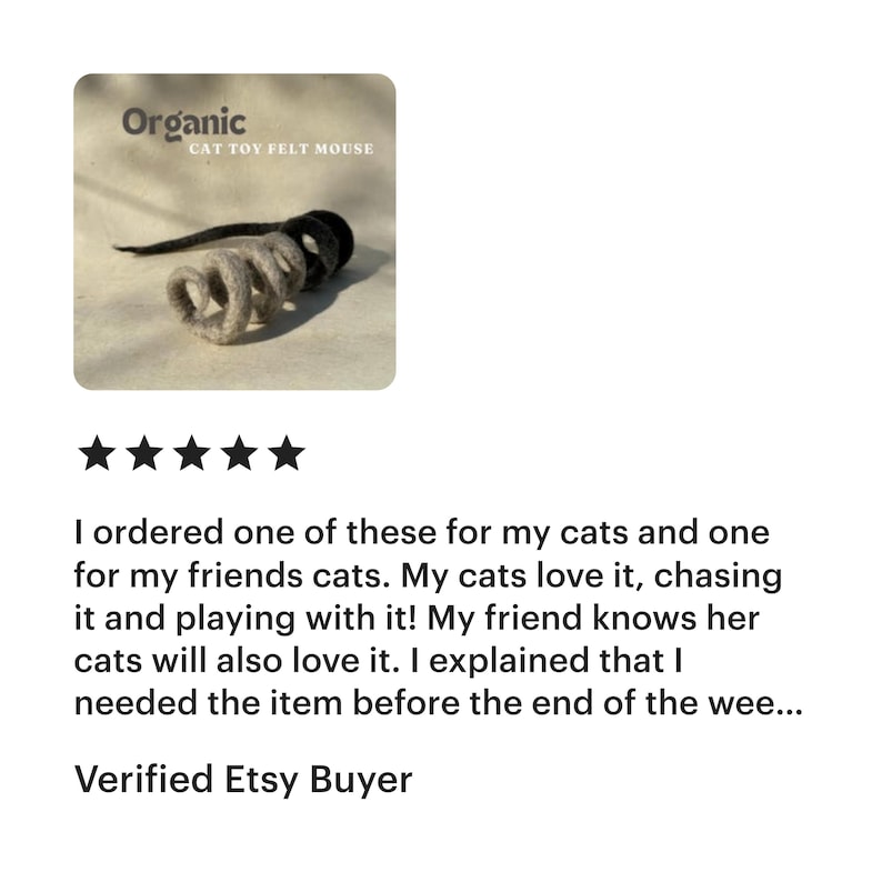 Op de afbeelding: Een organisch vilten kattenspeeltje in de vorm van een muis met een spiraalvormig, lichtgrijs lichaam en een donkergrijze staart. De tekst Organic CAT TOY FELT MOUSE staat in de linkerbovenhoek. Het speeltje heeft een zachte textuur.