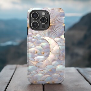 May include: A pearlescent phone case featuring a celestial design. The case showcases a crescent moon, stars, and sunburst against a backdrop of stylized clouds. The design incorporates gold accents and a textured, iridescent finish.