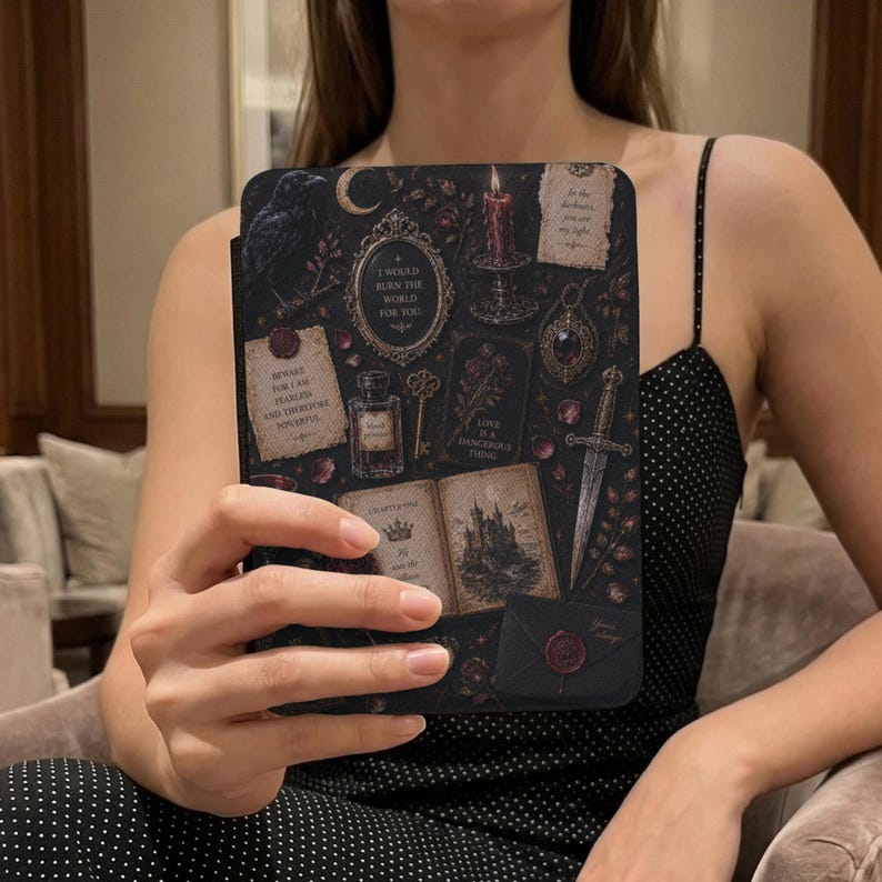 May include: A black e-reader case featuring a dark, gothic-inspired collage of a raven, a burning candle, a dagger, an open book with a castle illustration, a perfume bottle, a key, and parchment notes with text including I WOULD BURN THE WORLD FOR YOU.
