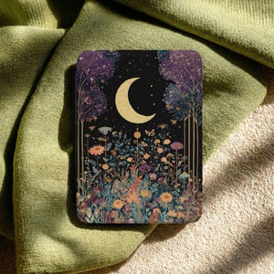 May include: A rectangular case featuring a black background with a gold crescent moon centered above a dense field of colorful wildflowers and tall trees. The illustration includes various floral shapes in shades of orange, blue, and purple.
