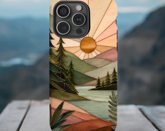 Puede incluir: Una funda para teléfono con una ilustración de paisaje estilo vidriera. El diseño muestra un sol saliendo sobre colinas, un lago tranquilo y árboles de hoja perenne en tonos verde, marrón, melocotón y crema con contornos oscuros.