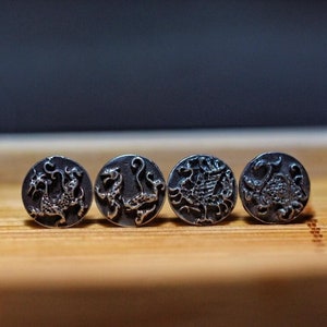 May include: Four silver-toned metal buttons with intricate dragon designs. Each button features a different dragon pose.