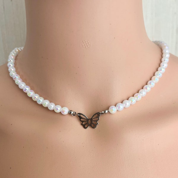 Collier de perles blanches avec pendentif de papillon.