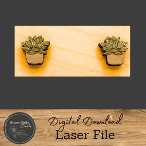 May include: A digital download laser file for two small succulent plant earrings. The earrings are made of wood and are painted green and brown. The earrings are shown on a wooden background.
