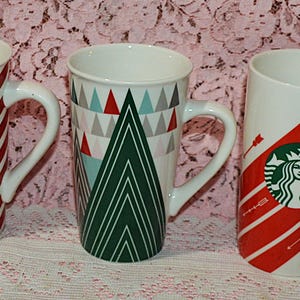 A lot of Three Collectible Starbucks Mugs - 1- 2019  Red and White Striped Christmas Mug - 1 -2020 Red Arrow Love Mug  and 1 - 2017  Tree