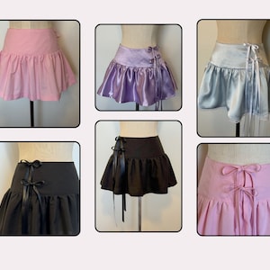 May include: Five different mini skirts with ribbon ties at the back. The skirts are in pink, purple, light blue, black, and dark pink.