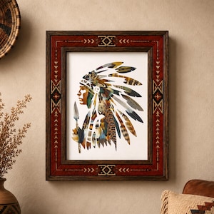 May include: A framed wall art piece featuring a profile illustration of a person wearing a large, multi-colored feather headdress and holding a spear. The frame is dark wood with a red border decorated with geometric patterns and white accents.