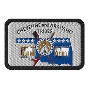 May include: Embroidered patch with the text "CHEYENNE and ARAPAHO TRIBES". The patch features a central design with a teepee, arrows, and a shield, set against a blue and white background, framed by a black border.