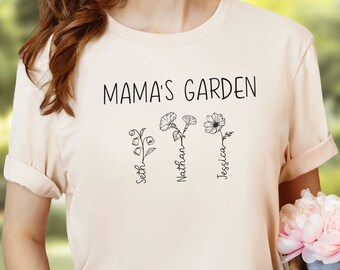 Può includere: Una maglietta beige con il testo "Mama's Garden" e tre fiori stilizzati con i nomi "Seth", "Nathan" e "Jessica" scritti sotto.