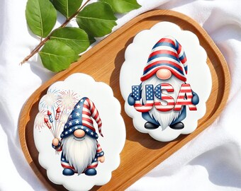 Peut inclure: Deux décorations en céramique blanches à bords festonnés représentant des gnomes patriotiques. L'un tient des feux d'artifice, l'autre le mot "USA". Les deux gnomes portent des chapeaux et des tenues rouges, blancs et bleus, célébrant la fête nationale.