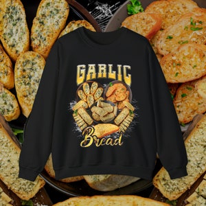 Könnte beinhalten: Schwarzes Sweatshirt mit einem grafischen Design von Knoblauchbrot. Das Design zeigt eine Herzform mit den Worten "Garlic Bread" in goldenen Buchstaben. Das Herz ist mit Bildern von Knoblauchbrot gefüllt.