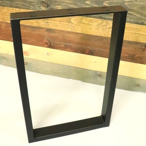 Op de afbeelding: Zwarte metalen tafelpoten met een rechthoekig frame. De poten zijn gemaakt van stevig metaal en hebben een zwarte poedercoating.