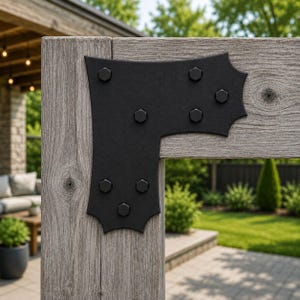 May include: A black L-shaped metal corner bracket with decorative scalloped edges, secured to a weathered gray wooden post and beam structure with seven matching black hexagonal bolts arranged in a symmetrical pattern across the surface.