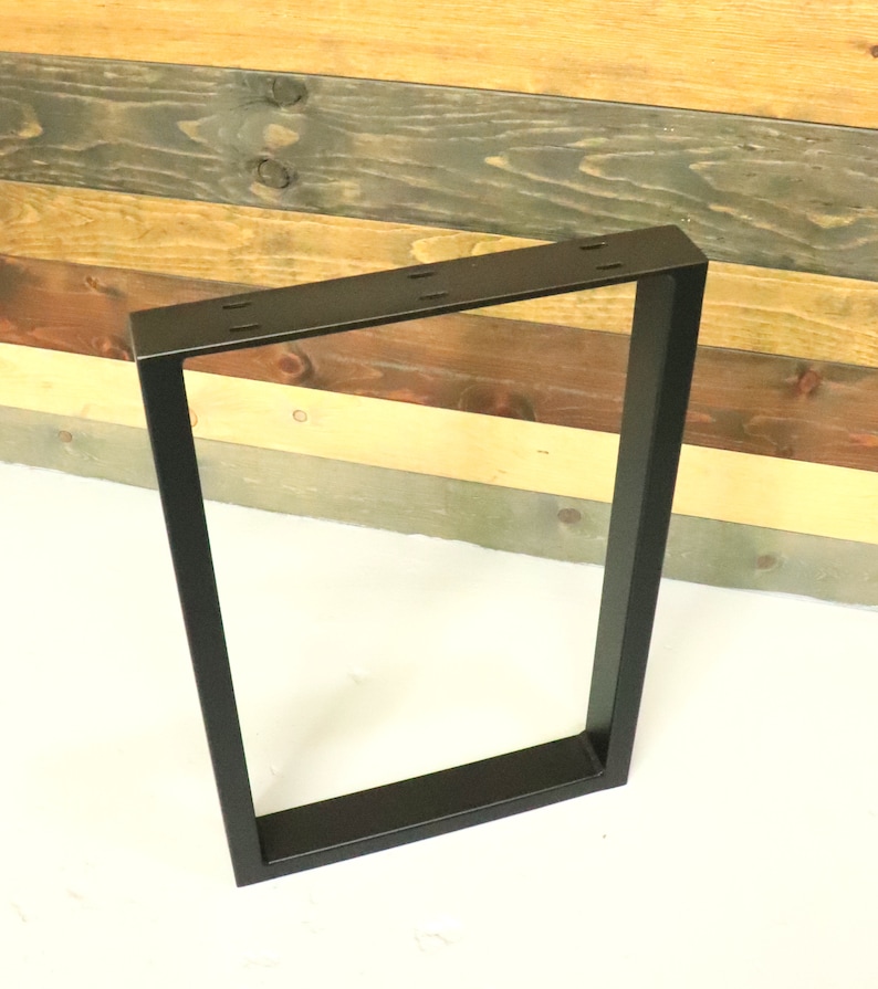 Op de afbeelding: Zwarte metalen tafelpoot met een rechthoekig frame. De poot is gemaakt van stevig metaal en heeft een zwarte afwerking.