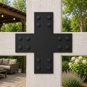 May include: A black metal cross-shaped connector plate featuring twelve hexagonal bolt heads, secured over the intersection of two white-painted wooden beams. The heavy-duty steel bracket provides structural reinforcement for the timber frame.