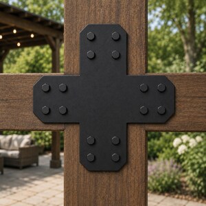 May include: A black metal cross-shaped structural connector plate secured with sixteen hexagonal bolts, mounted over the intersection of two brown wooden beams. The plate features a flat, matte finish and chamfered corners at each end.