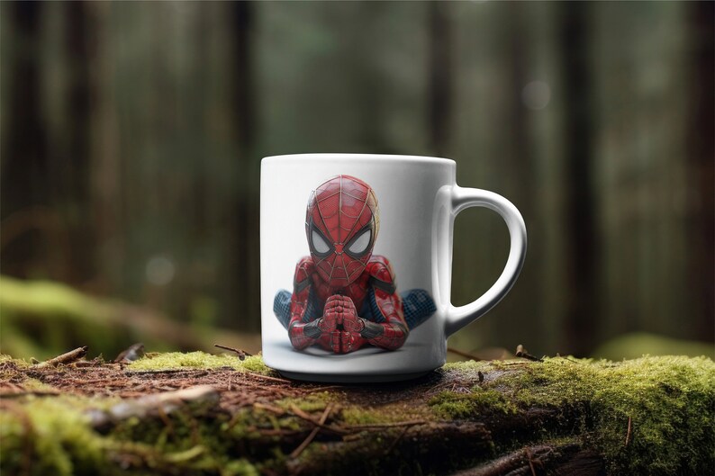 K&ouml;nnte beinhalten: Wei&szlig;e Keramiktasse mit einer detaillierten Illustration von Spider-Man in meditativer Pose. Der Superheld ist in seinem klassischen rot-blauen Anzug dargestellt, die H&auml;nde vor sich gefaltet. Die Tasse hat einen Standardgriff.