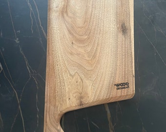 May include: A light brown wooden cutting board with a unique curved handle. The board has a natural wood grain pattern and the text "WOOD SEGMENT" is engraved on the surface.