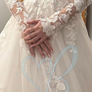 Guantes de novia sin dedos con encaje floral y mangas desmontables hasta el bíceps.