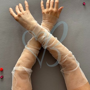 K&ouml;nnte beinhalten: Ein Paar durchsichtige wei&szlig;e Ellbogenlange Handschuhe aus T&uuml;ll.