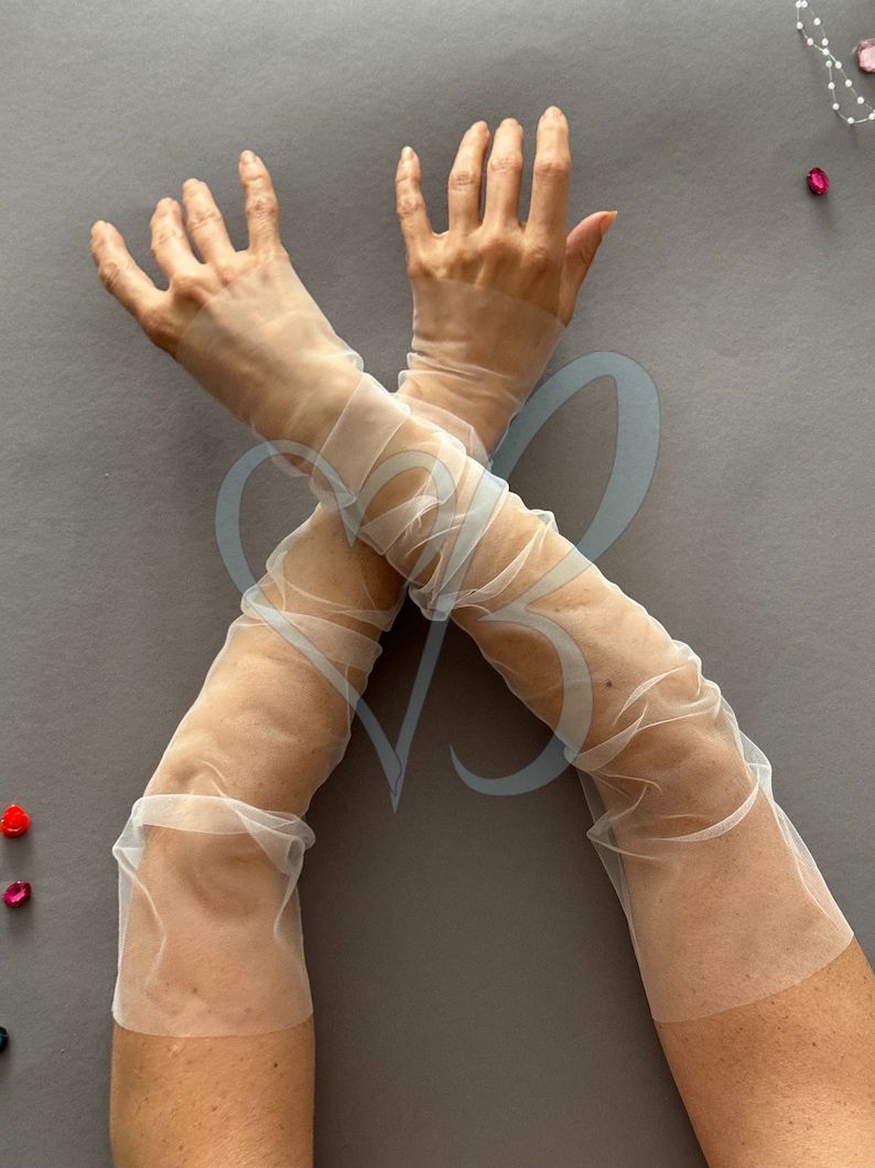 K&ouml;nnte beinhalten: Ein Paar durchsichtige wei&szlig;e Ellbogenlange Handschuhe aus T&uuml;ll.
