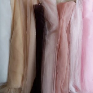 K&ouml;nnte beinhalten: Sortiment von zehn durchsichtigen Stoffproben in verschiedenen Farben, darunter Wei&szlig;, Beige, Braun, Rosa, Hellrosa, Rot und Blau.