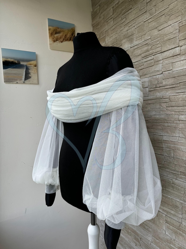 May include: White tulle off-the-shoulder sleeves with puffed long sleeves. The sleeves are made of a soft, sheer fabric and are perfect for adding a touch of elegance to any outfit.