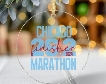 May include: A clear round ornament with a blue background and red text that reads "Chicago 2022 finisher Marathon".