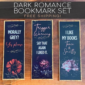 Op de afbeelding: Een set van drie dark romance bladwijzers met gouden rand. Elke bladwijzer heeft tekst en bloemenillustraties. De tekst bevat zinnen als "Morally Grey? Yes please" en "I like my books toxic & smutty."