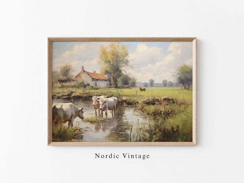 May include: A painting of a rural landscape with a white farmhouse, a stream, and cows grazing in a field. The sky is blue with white clouds. The painting is framed in a light wood frame.