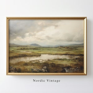 May include: A framed landscape painting with a gold-colored frame. The artwork depicts a marshy landscape with green and brown vegetation, a body of water, and rolling hills under a cloudy sky. The text "Nordic Vintage" is at the bottom.