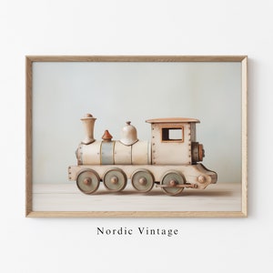 May include: A vintage wooden toy train with a white and brown paint finish. The train has a bell and a chimney on top. The train is on a wooden surface. "Nordic Vintage" is written below the train.