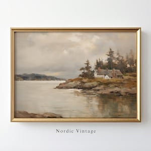 May include: A framed painting of a cottage on a rocky shore with a body of water in the foreground. The sky is cloudy and the water is calm. The painting is in a gold frame.