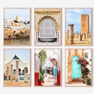 Può includere: Set di sei stampe artistiche incorniciate con architettura marocchina. Le immagini mostrano varie scene, tra cui una città costiera, una fontana a mosaico, un minareto e una porta turchese. Le stampe sono in cornici dai toni neutri.