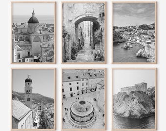 May include: Set of six black and white photographs featuring various architectural details of a city. The photos show a church, a narrow street, a courtyard, and a fortress.