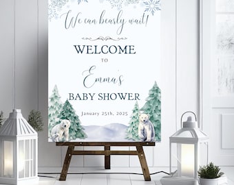 Może przedstawiać: Tablica powitalna na baby shower w zimowym stylu z niebiesko-białym wzorem śnieżynek. Na tablicy widnieje napis "We can barely wait! Welcome to Emma's Baby Shower January 25th, 2025". Dwa niedźwiedzie polarne stoją przed zasneżonym lasem.