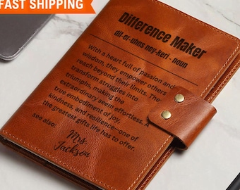 Può includere: Un diario in pelle marrone con una chiusura dorata e le parole "Difference Maker" incise sul davanti. Il diario contiene anche la definizione della parola "Difference Maker" e il nome "Mrs. Jackson" inciso sul davanti.