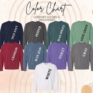 May include: A color chart showcasing Comfort Colors sweatshirts in various hues. The sweatshirts are displayed in colors such as True Navy, Pepper, Blue Spruce, Light Green, Crimson, Blue Jean, Violet, Gray, and White. The text "Color Chart" is at the top.