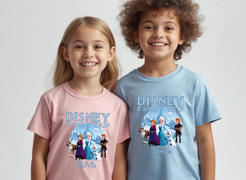 May include: Two children wearing matching t-shirts. The shirts are light pink and light blue, each with a "Disney Family Trip" graphic featuring characters from the movie Frozen. The pink shirt has the name "Olivia" and the blue shirt has the name "James".