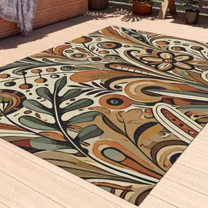 May include: A colorful, abstract floral patterned rug with shades of brown, orange, green, and cream. The rug is laid out on a wooden deck.
